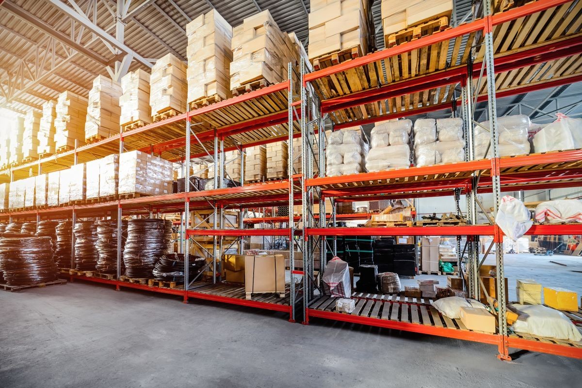 Warehouse of transport and logistics company. Long shelves with a variety of boxes and containers Bright sunlight.